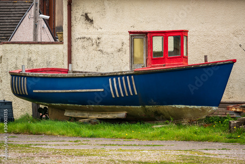 An old boat in front of a house, seen in Millom, Cumbria, England, UK photo