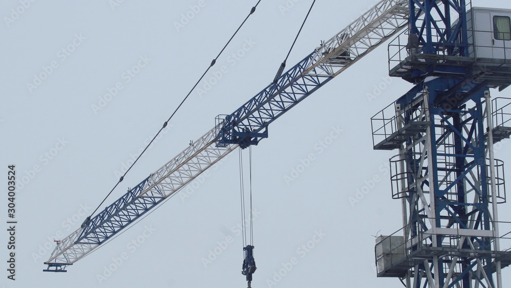 Tower crane lifts cargo onto a building under construction Tower crane lifts cargo onto a building under construction