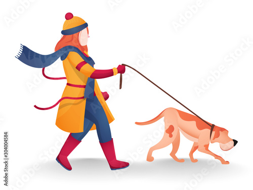 Young woman wearing woolen clothes and holding dog leash in walking pose.