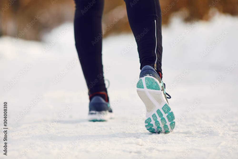 Closeup of girl runner's feet in park in winter Closeup of girl runner's feet in park in winter