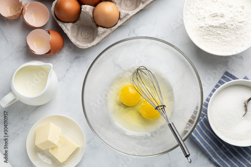 Valokuvatapetti baking cake ingredients (eggs, flour, sugar, butter and milk) on white table