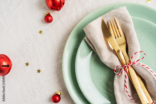 Close view of golden cutlery on light napkin for Christmas table setting.