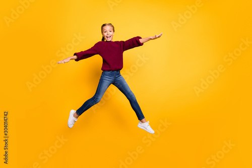 Full length body size view of nice attractive lovely carefree glad girlish cheerful cheery pre-teen girl jumping having fun flying isolated on bright vivid shine vibrant yellow color background