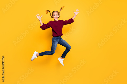Full length body size photo of cheerful positive excited gitl in jeans denim burgundy sweater jumping up footwear isolated vivid color background