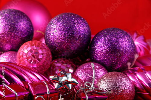 Christmas gifts lying on their side in front of Christmas baubles