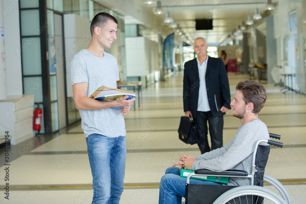 Obraz premium thoughtful disabled boy in wheelchair in corridor at school