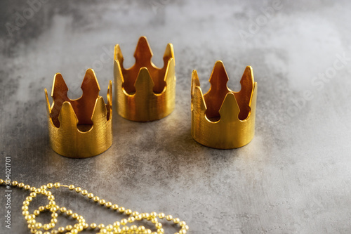Fényképezés Three gold crowns on black background, symbol of Tres Reyes Magos  ( Three Wise Men) who come bringing gifts for the kids on Epiphany or Dia de Reyes Magos