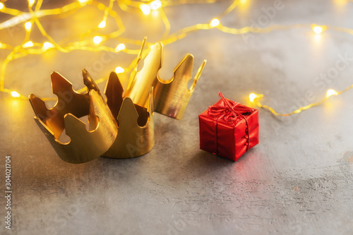 Obraz na płótnie Three gold crowns and red gift box for concept of Epiphany or Dia de Reyes Magos ,  where in Spain giving gift a kids