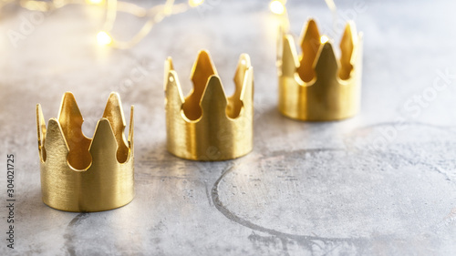 Three gold crowns on black background, symbol of Tres Reyes Magos  ( Three Wise Men) who come bringing gifts for the kids on Epiphany or Dia de Reyes Magos. photo