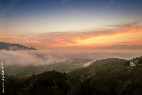 Mountain view misty morning above Kok river and Tha Ton city in valley around with sea of mist with cloudy sky background, sunrise at Wat Tha Ton, Fang, Chiang Mai, northern of Thailand.