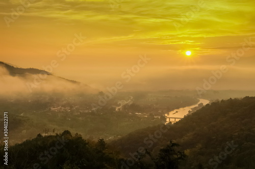 Mountain view panorama misty morning above Kok river and Tha Ton city in valley around with sea of mist and yellow sky background, sunrise at Wat Tha Ton, Fang, Chiang Mai, northern of Thailand.