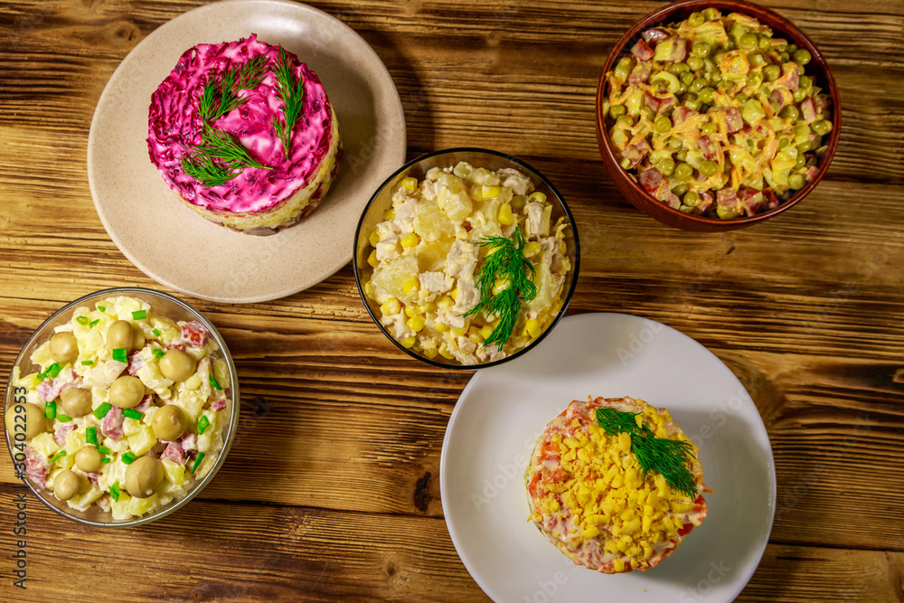 Set of festive mayonnaise salads on wooden table. Top view