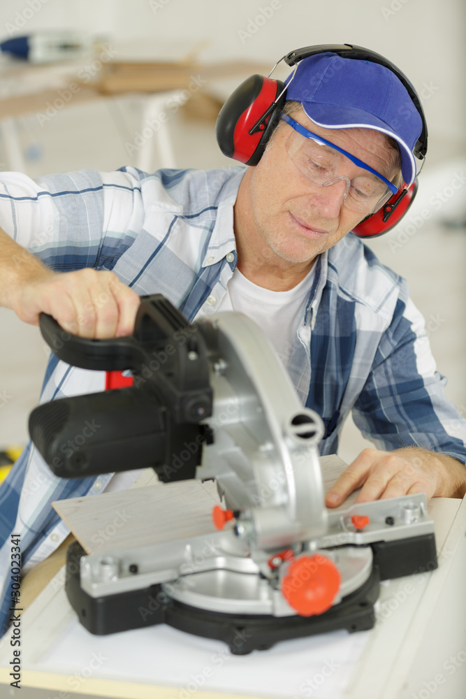 mature man using circular saw mature man using circular saw