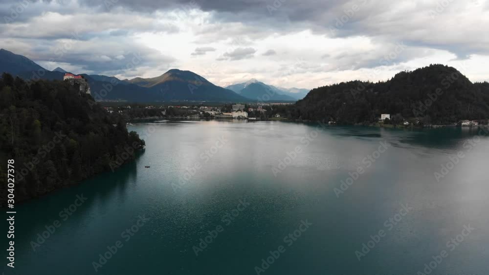 Bled lake, Bled Castle on top of hill on cloudy day. Slovenia. Aerial pan right Bled lake, Bled Castle on top of hill on cloudy day. Slovenia. Aerial pan right