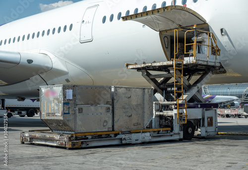 Air cargo logistic containers are loading to an airplane.