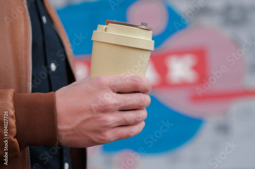 a man holds an eco mug in his hands. ecology concept. environmental concern.