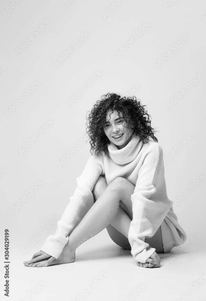 Portrait of lovely woman with curly hair in warm cozy sweater