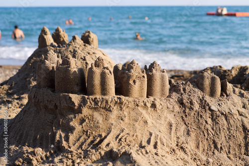 Landscape.Children's sand castle on a background of blue sea.Concept of family and tourism.