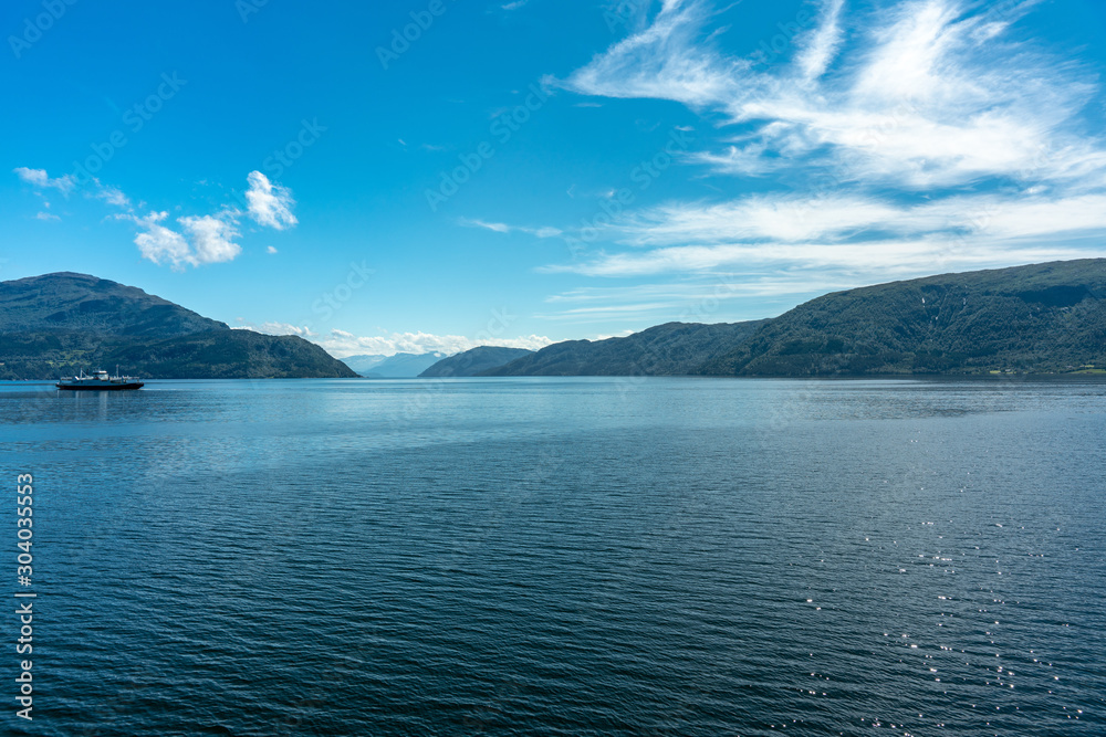 Beautiful fjord or bay in Norway  in summer with a ferry crossing the water