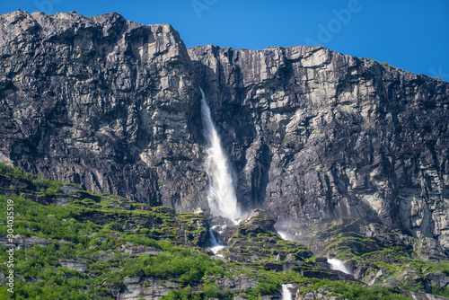 Vinnufallet in summer sunlight, flushing down a steep mountainside in Norway