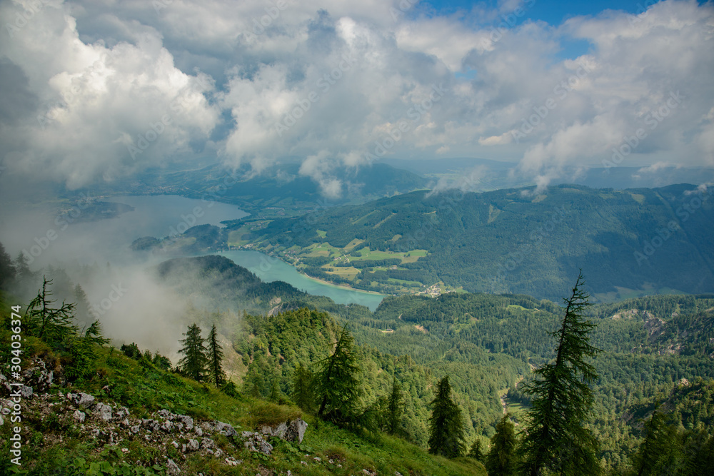 view of mountains through clouds in valley with wolfgangsee