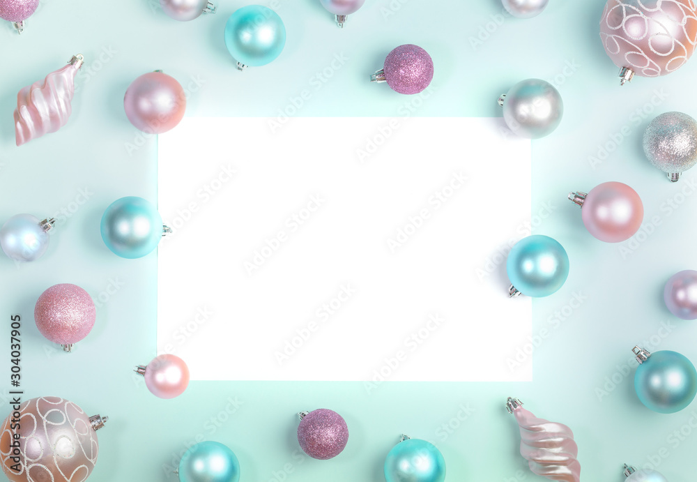 Christmas festive mockup flat lay of Christmas balls around blank white sheet on trendy Neo Mint background. 