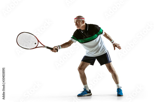 Senior man wearing sportwear playing tennis isolated on white background. Caucasian male model in great shape stays active and sportive. Concept of sport, activity, movement, wellbeing. Copyspace, ad. © master1305