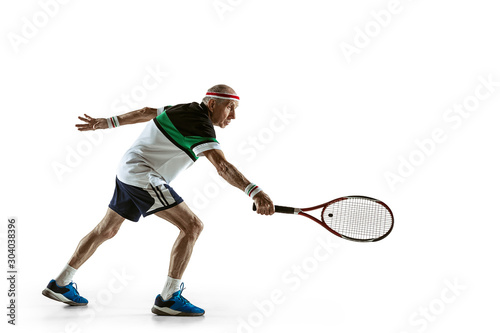 Senior man wearing sportwear playing tennis isolated on white background. Caucasian male model in great shape stays active and sportive. Concept of sport, activity, movement, wellbeing. Copyspace, ad. © master1305