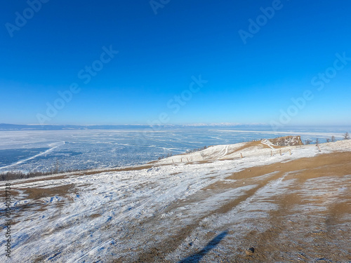dry landscape of frozen lake and mountain hill covered with white snowing winter