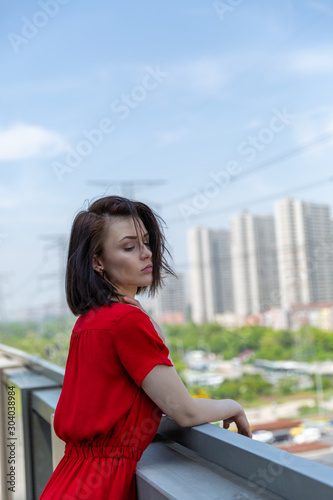 girl in a red dress on the roof overlooking the city