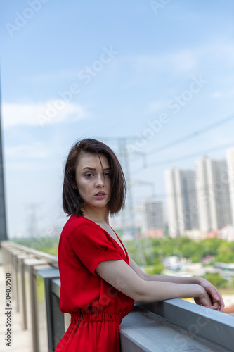girl in a red dress on the roof overlooking the city