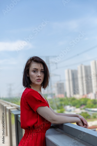girl in a red dress on the roof overlooking the city
