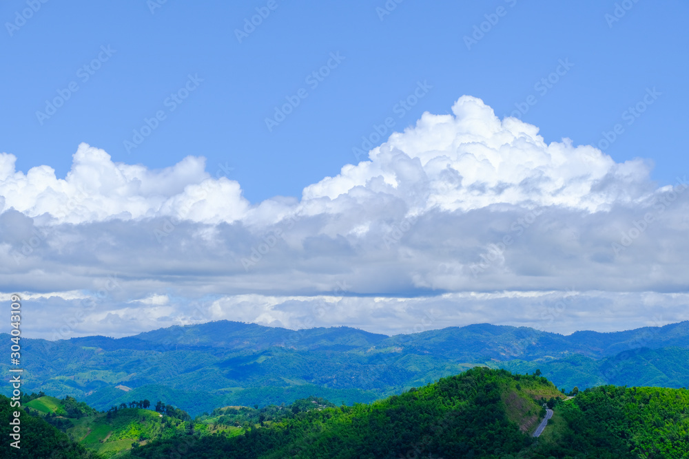 Beautiful blue sky with white gorgeous fluffy cloudy flowing with the wind over the mountain