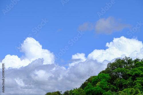 Beautiful blue sky with white gorgeous fluffy cloudy flowing with the wind over the mountain © 168 Studio
