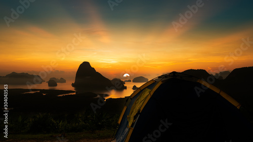 Shot of Silhouette scene mountain of sun rises at Samed Nang Chee or Samed Namshe Island which have tent at the foreground  Phang Nga Province Thailand. The beautiful viewpoint from southern Thailand.