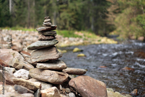 Photography pile of stones on stony river bank in the forest
