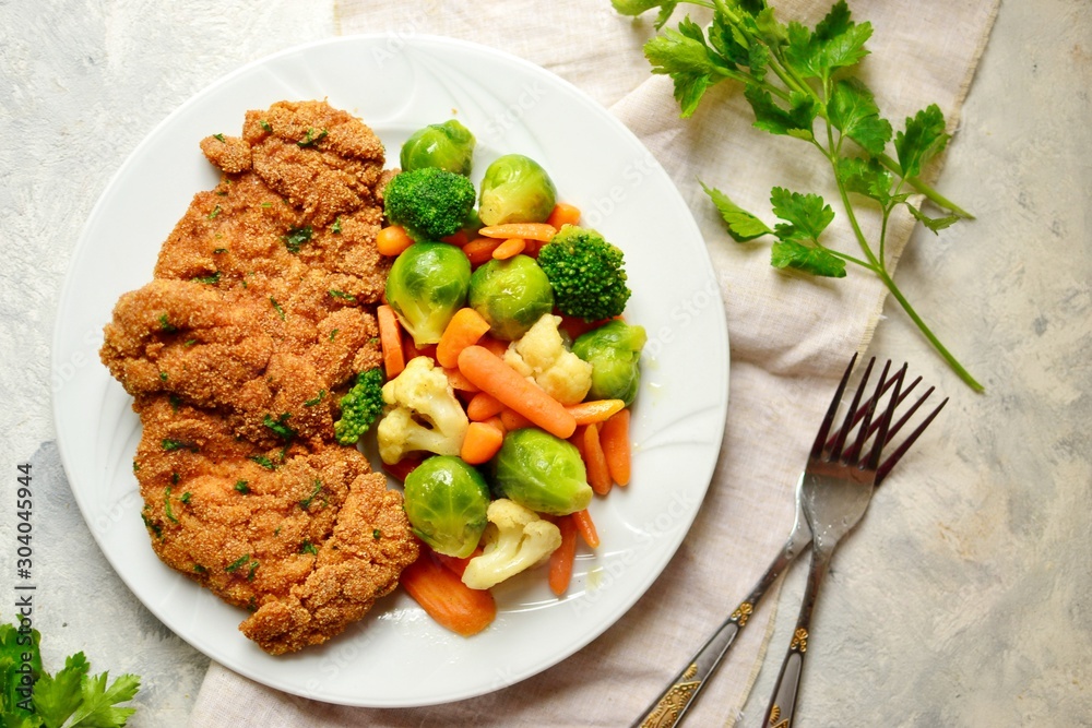Chicken breast with vegetables. Baked chicken fillet, carrots, Brussels sprouts, broccoli, cauliflower. Food in a plate on a light wooden background. Chicken breast with vegetables. Baked chicken fillet, carrots, Brussels sprouts, broccoli, cauliflower. Food in a plate on a light wooden background.