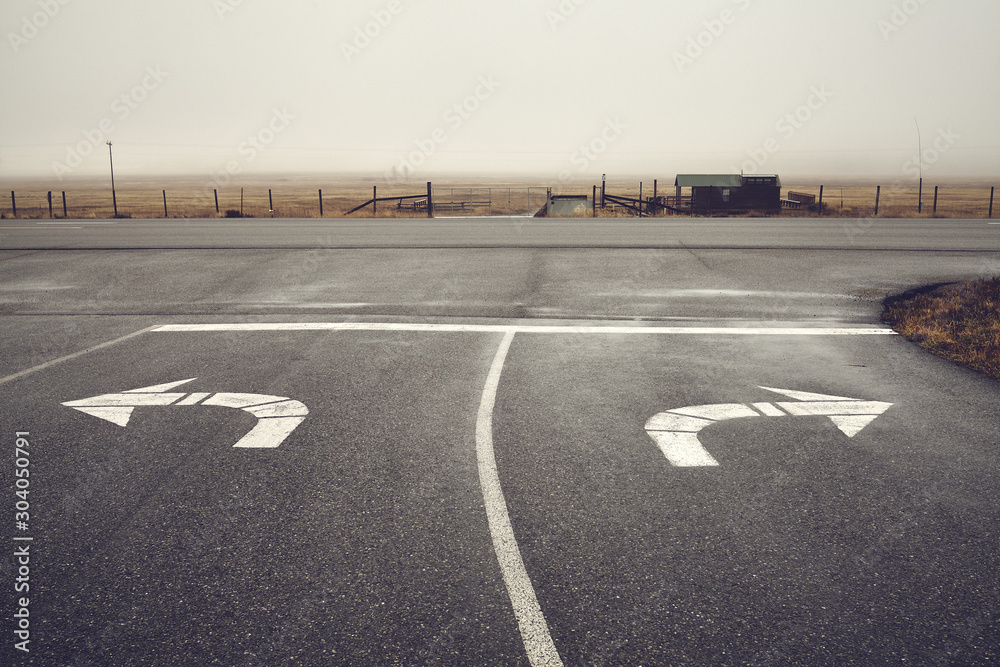 Left or right, roads intersection on a rainy day, color toning applied, Wyoming, USA. - obrazy, fototapety, plakaty 