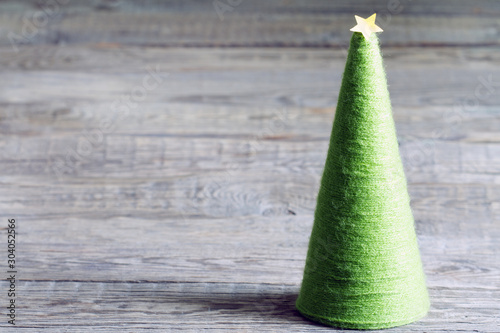 Christmas tree made from woolen yarn with yellow star on wooden boards