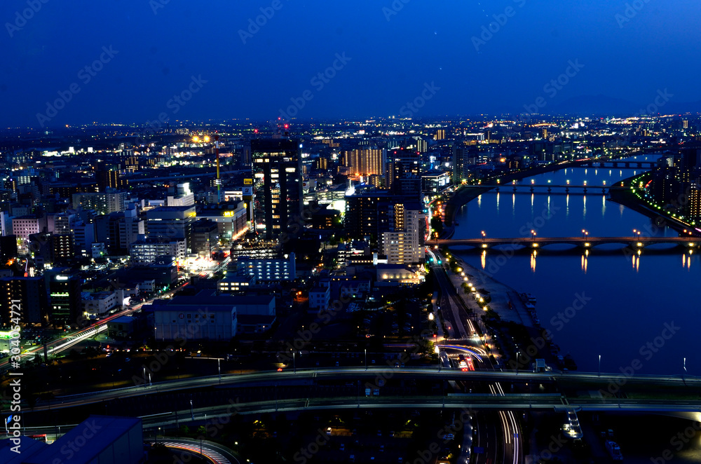 Fototapeta premium 新潟市の夜景。Befcoばかうけ展望室（朱鷺メッセ）から望む信濃川とライトアップされた萬代橋、市街地のパノラマ。