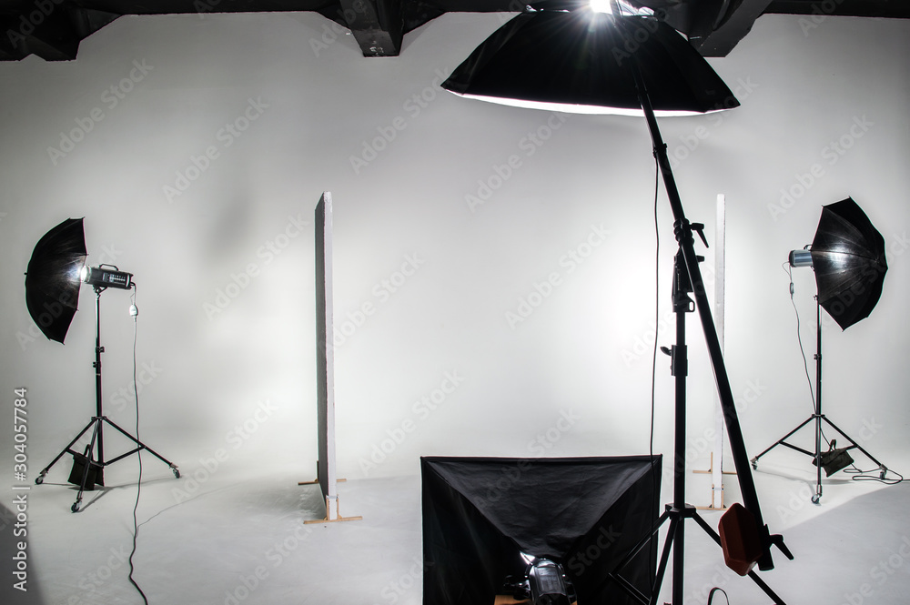 The interior of the photo studio. Preparing to work with photographic equipment. Cyclorama, background, exposure to light on the octobox, softbox. - obrazy, fototapety, plakaty 