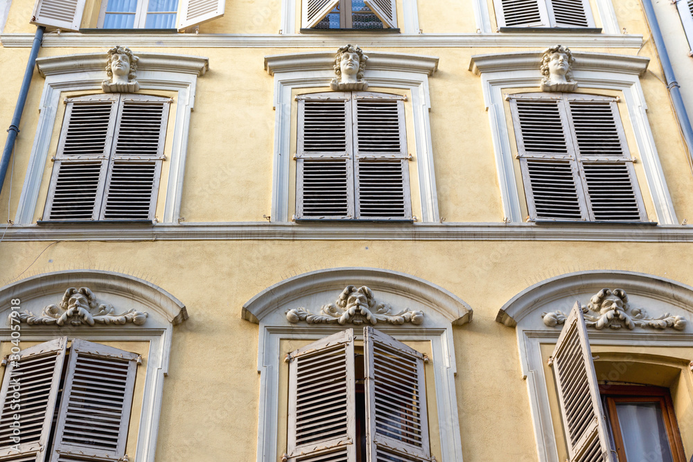 detail of typical French building. Yellow with faded shutters in Antibes, cote d'azur or the French Riviera