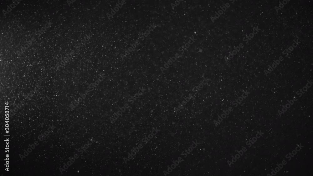 Natural Organic Dust Particles Floating On Black Background. Dynamic Dust Particles Randomly Float In Space With Fast And Slow Motion. Shimmering Glittering White Particles With Bokeh In The Air. Natural Organic Dust Particles Floating On Black Background. Dynamic Dust Particles Randomly Float In Space With Fast And Slow Motion. Shimmering Glittering White Particles With Bokeh In The Air.