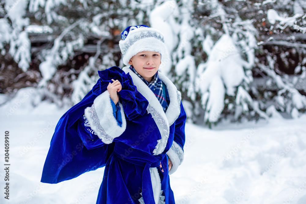 A boy in a suit of Father Frost with a bag of gifts. Winter day. Cristmas presents. Winter, russian Christmas character Father Frost.