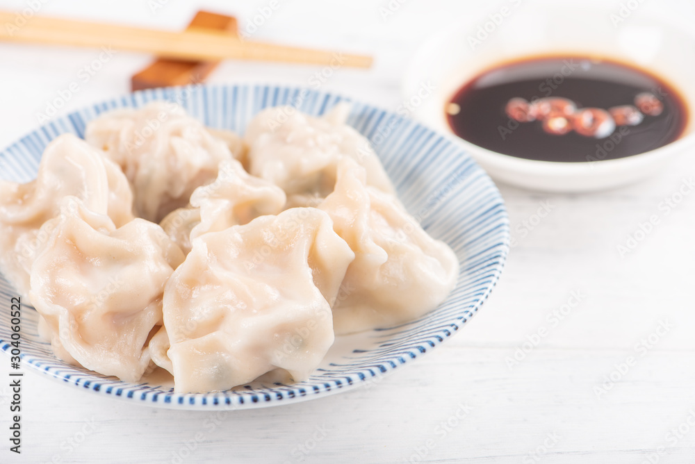 Fresh, delicious boiled pork, shrimp gyoza dumplings on white background with soy sauce and chopsticks, close up, lifestyle. Homemade design concept. Fresh, delicious boiled pork, shrimp gyoza dumplings on white background with soy sauce and chopsticks, close up, lifestyle. Homemade design concept.
