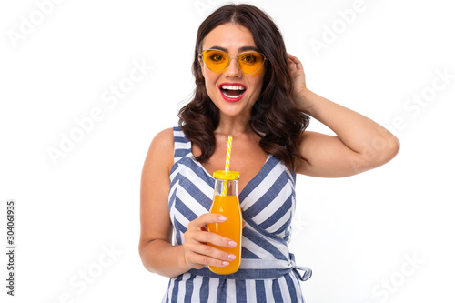 Beautiful young woman with perfect smile, sunglasses drinks juice and smiles, isolated on white background