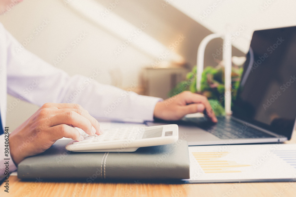 Calculate the calculator, Male employees work in private rooms Calculating company revenue figures with calculator, Financial accounting concepts Calculate the calculator, Male employees work in private rooms Calculating company revenue figures with calculator, Financial accounting concepts