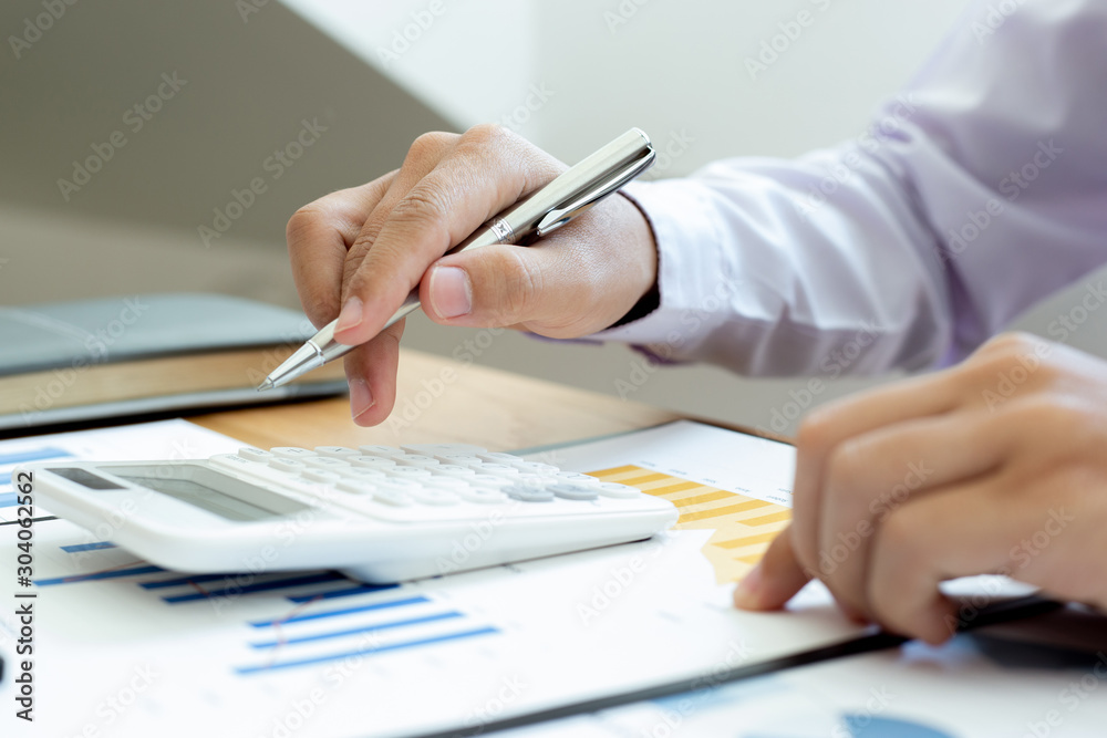Calculate the calculator, Male employees work in private rooms Calculating company revenue figures with calculator, Financial accounting concepts Calculate the calculator, Male employees work in private rooms Calculating company revenue figures with calculator, Financial accounting concepts