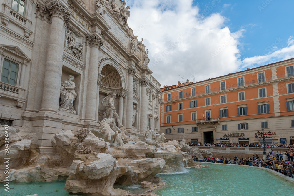 Rome, Italy - October 07, 2018: The Trevi Fountain standing 26 meters high and 20 meters wide, it is the largest Baroque fountain in the city. Fountain di Trevi surronded by hundreds of tourists