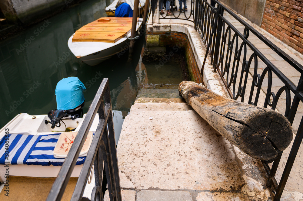 Venice, Italy, Old motor boat moored in a narrow channel.